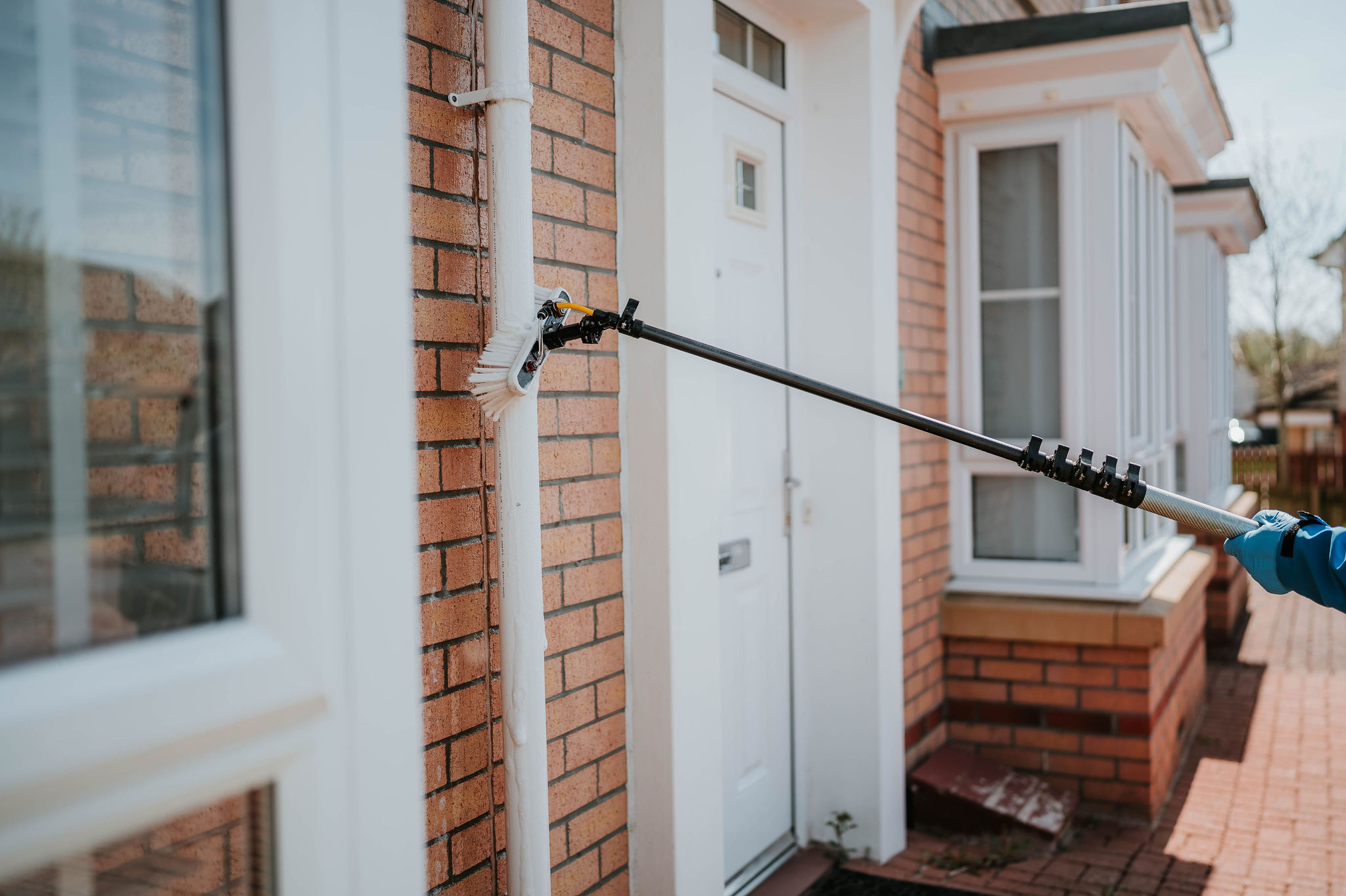 Gutter clearing service by Plourde Exterior Cleaning removing debris from residential gutters