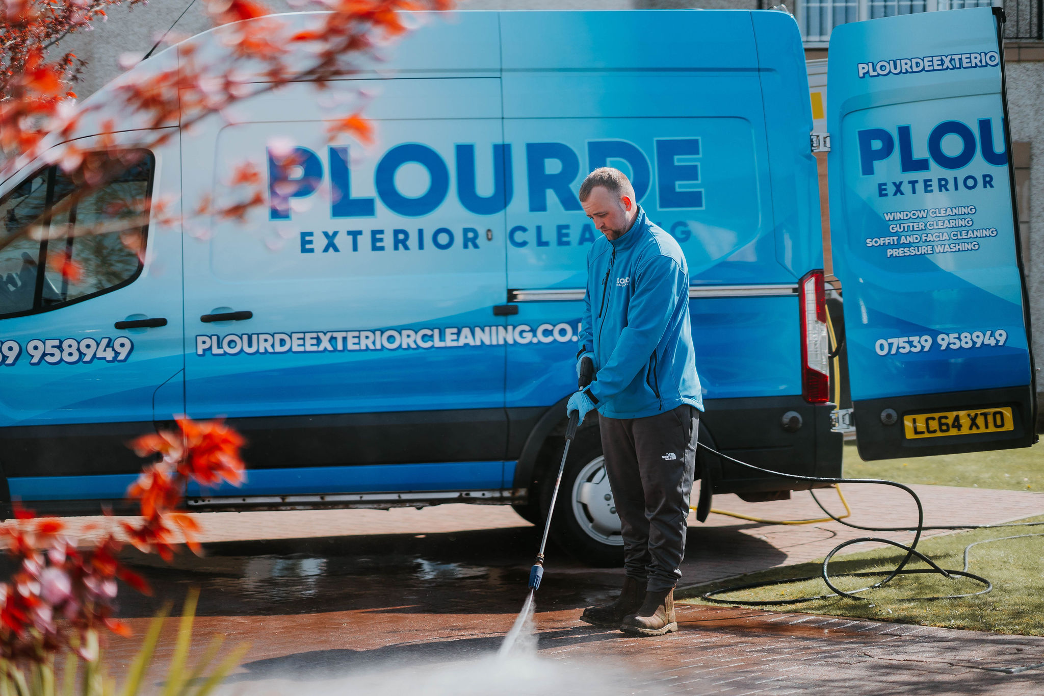 Professional pressure washing cleaning a residential driveway in East Kilbride, removing algae and staining